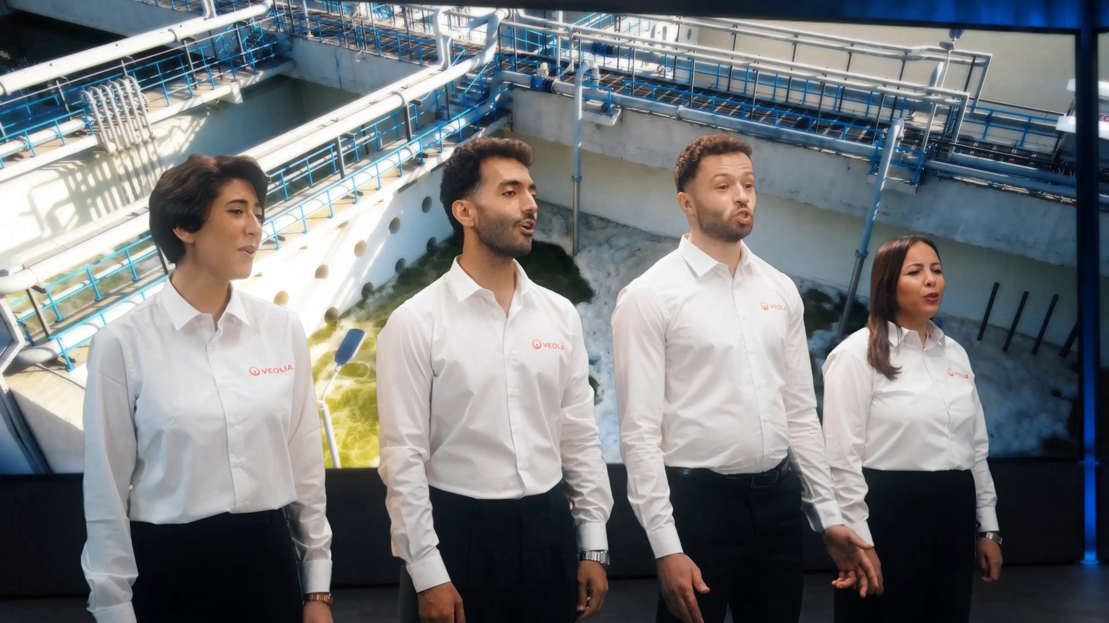 Four Veolia singers performing in front of water treatment imagery